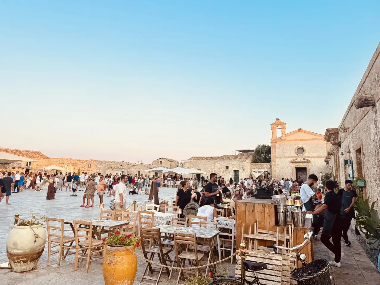 Ein belebter Platz in Palermo mit Kindern, Familien und Restaurants.