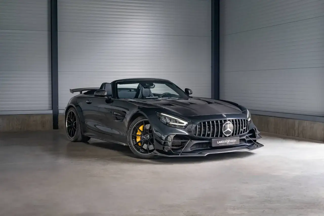 Schwarzer Mercedes-AMG GTR Roadster mit gelben Bremss&auml;tteln und Carbon-Details steht in einer Garage.
