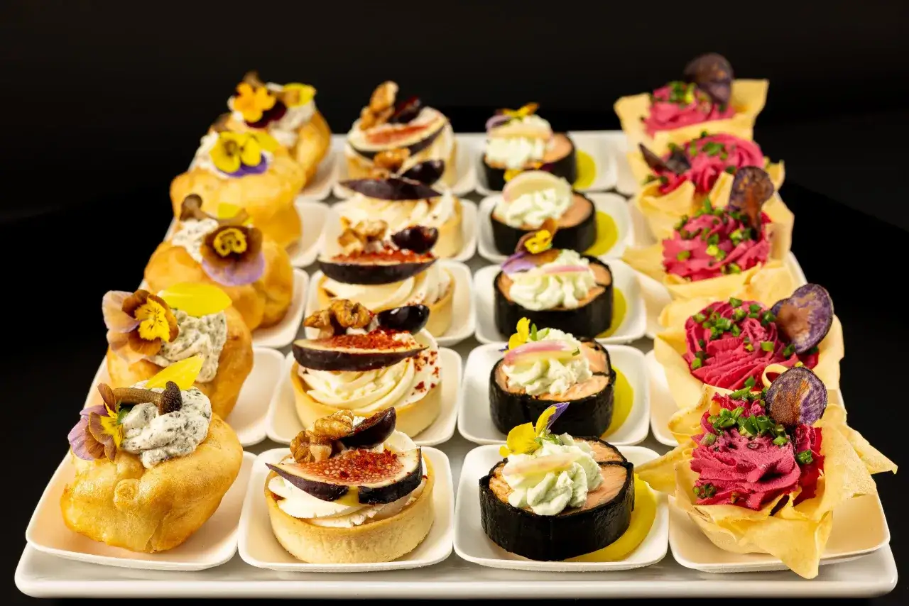 Elegancki catering na konferencje: wytrawne i słodkie przekąski, w tym tartaletki z figami, rolki z łososiem i musy w wafelkach.