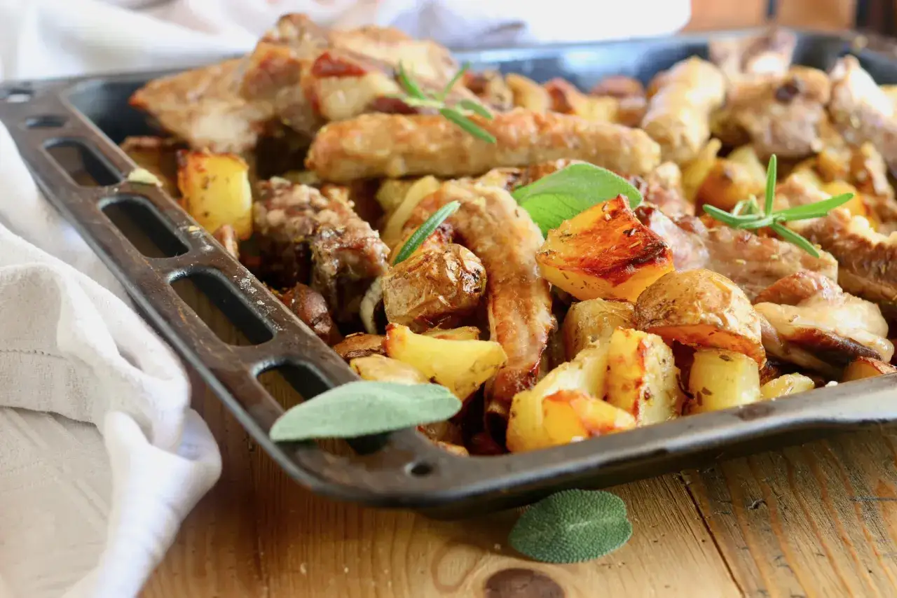 Salsiccia e patate al forno, un piatto rustico e saporito, cotto in teglia con erbe aromatiche.