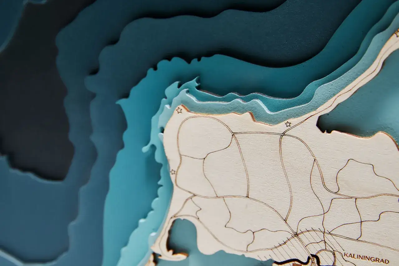 Warstwowa mapa z drewnianymi elementami. Czy Zatoka Gdańska to morze? Ta mapa pokazuje wybrzeże i głębiny, sugerując, że to część większego akwenu.