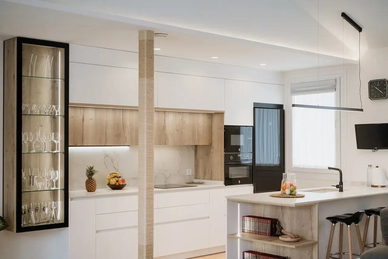 Cuisine moderne et épurée, une cuisine sans poignée aux finitions bois et blanc, avec une vitrine lumineuse et des appareils intégrés.