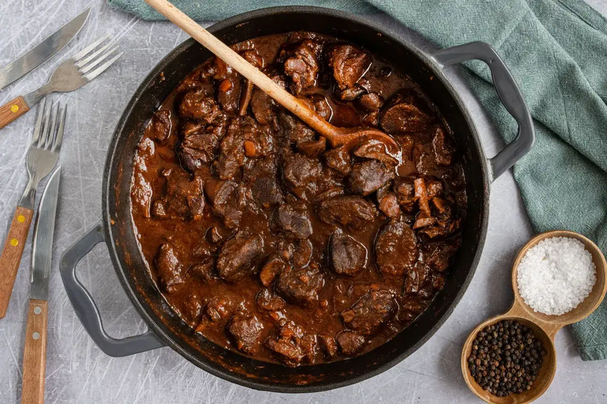 Herzhafter Rehgulasch in dunkler Sauce, bereit zum Schmoren. Die Frage