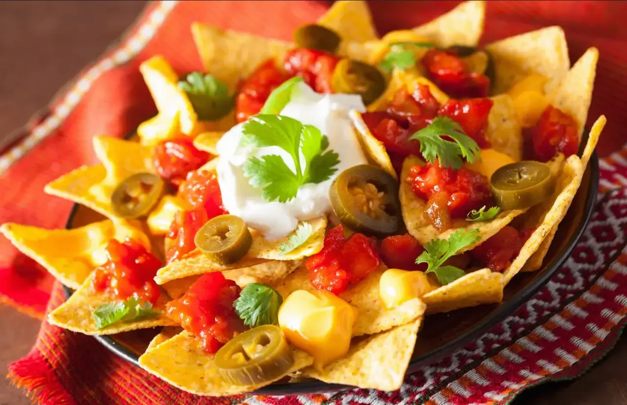 Nachos mit K&auml;se, Salsa, Jalape&ntilde;os und Sauerrahm. Ein k&ouml;stlicher Unterschied zu einfachen Tortillas!
