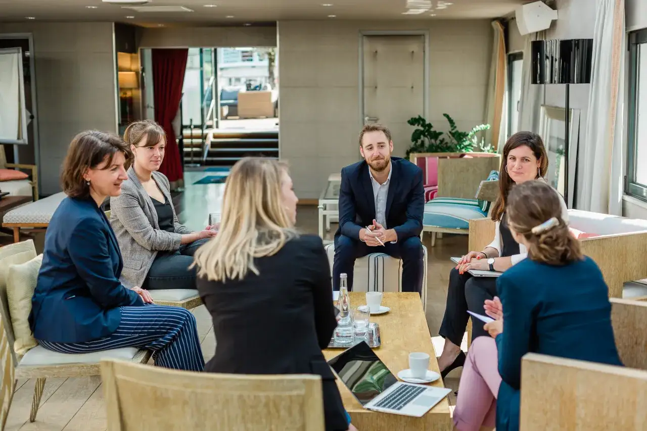 Des employés discutent autour d'une table lors d'un programme séminaire entreprise.