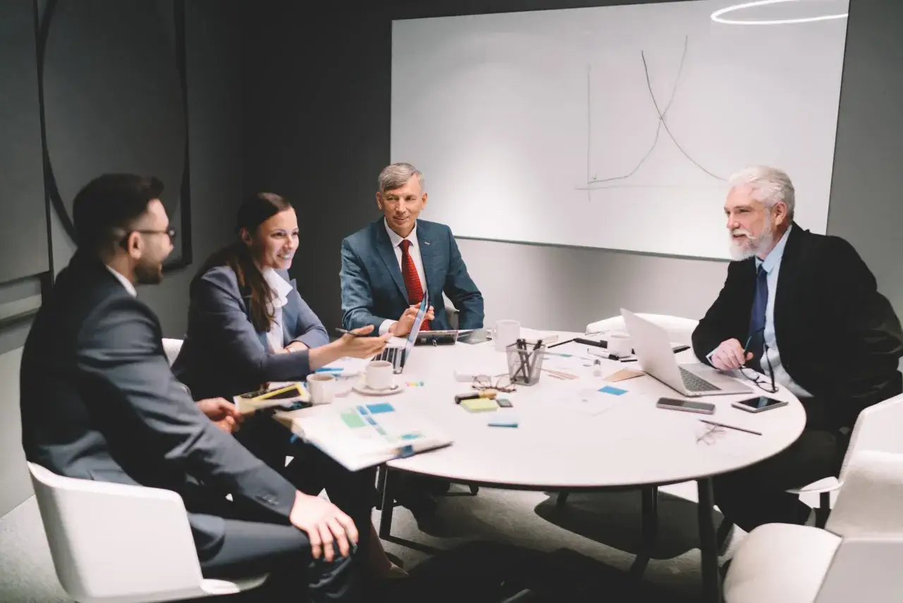 Business meeting discussing charts on a whiteboard, a common scene that can sometimes reflect institutional inertia despite efforts to innovate.