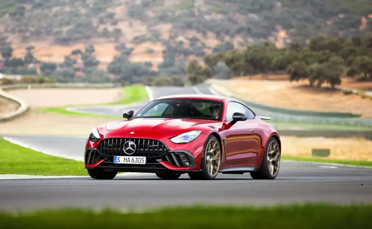 Czerwony Mercedes GT 63 na torze wyścigowym, z kierowcą za kierownicą.