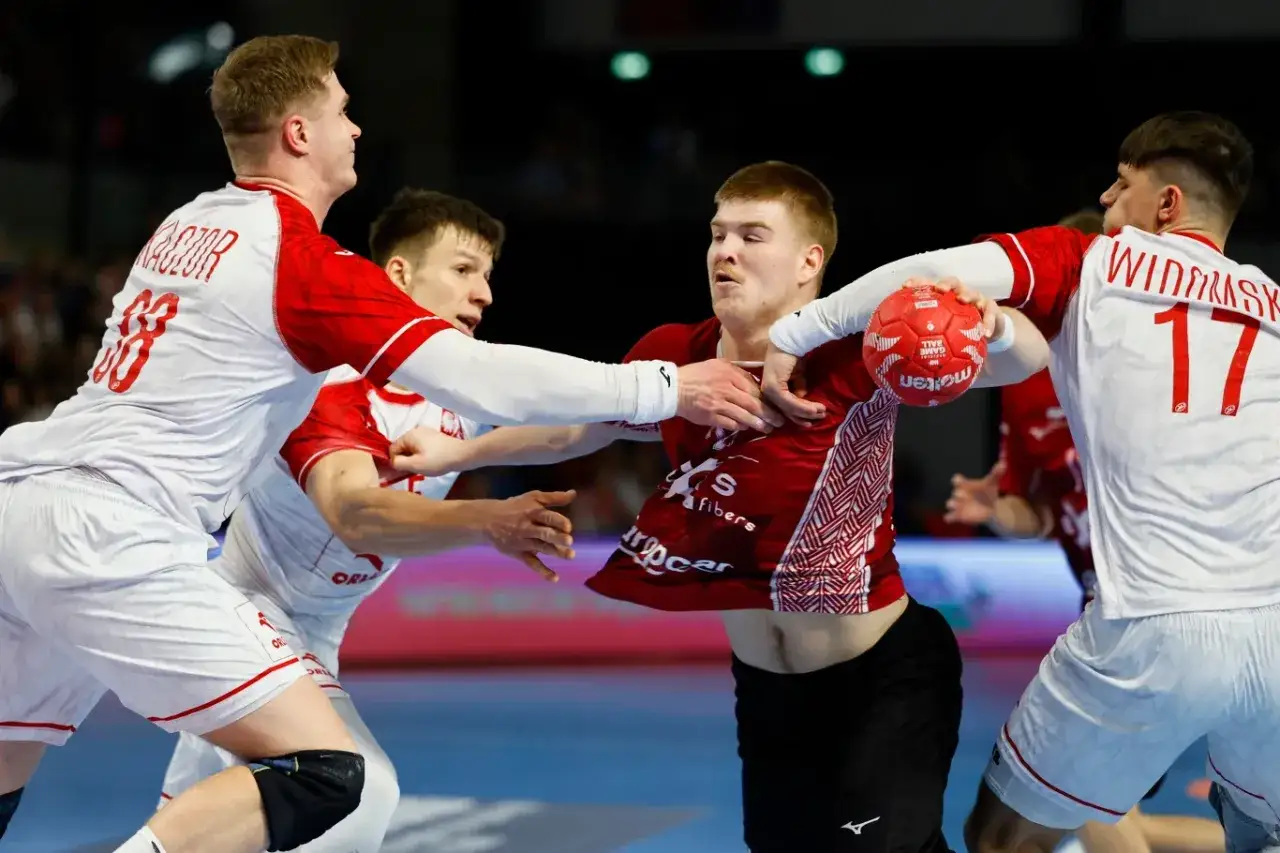 Zacięta walka na boisku. Polska Łotwa piłka ręczna w akcji, zawodnicy walczą o każdą piłkę.