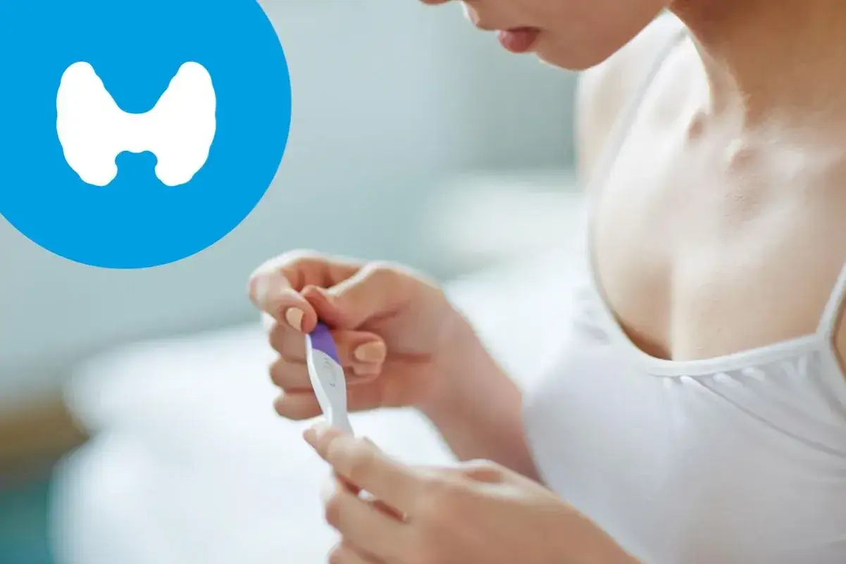 Kobieta trzyma test ciążowy. Obok symbol tarczycy, sugerujący, że tsh norma jest ważna w tym okresie.