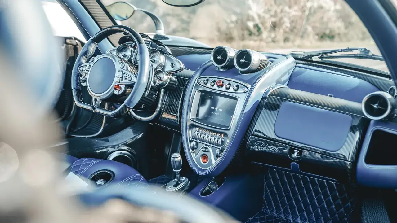 Wnętrze Pagani Huayra Roadster w kolorze niebieskim, z ekranem dotykowym i przyciskami. Cena tego cacka jest astronomiczna.