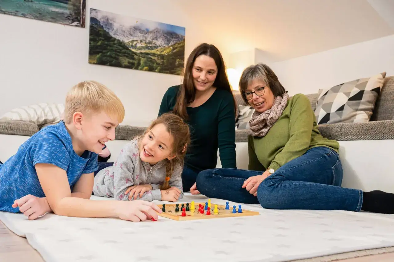Familie spielt Brettspiel, ein Beispiel f&uuml;r die besten Familienspiele ab 10 Jahre.