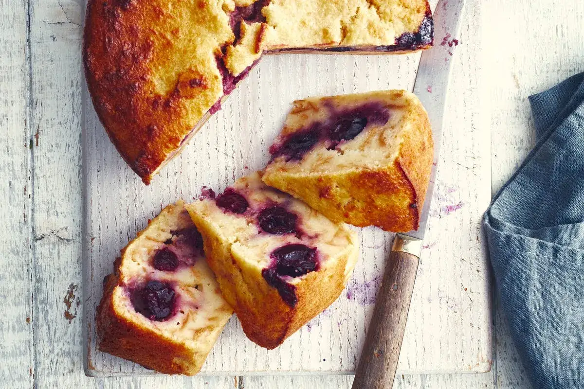 G&acirc;teau aux cerises, une d&eacute;licieuse recette mendiant alsacien, coup&eacute; en tranches sur une planche en bois.