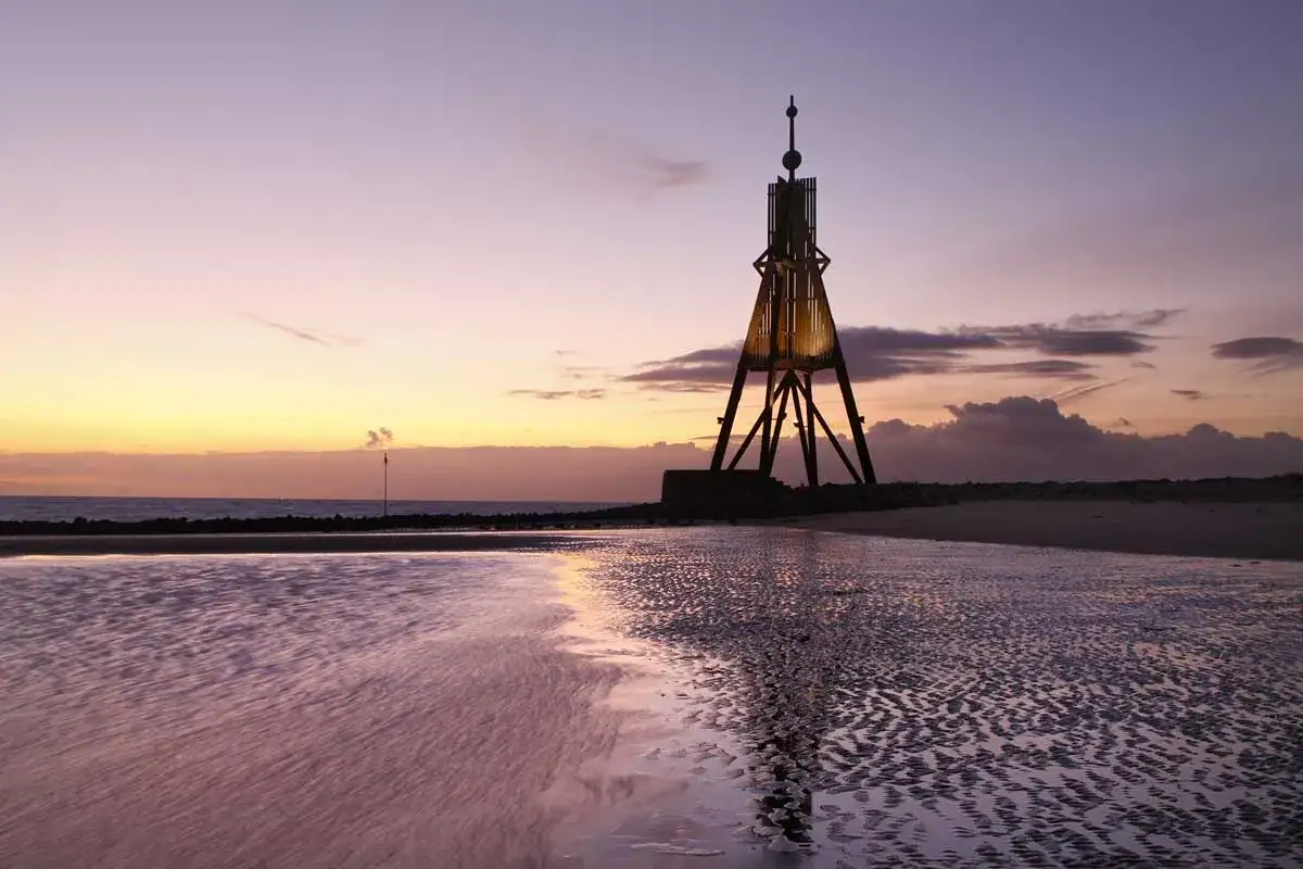 Leuchtturm am Strand bei Sonnenuntergang. Ein toller Ort, um zu entspannen und zu sehen, was man in Cuxhaven machen kann.