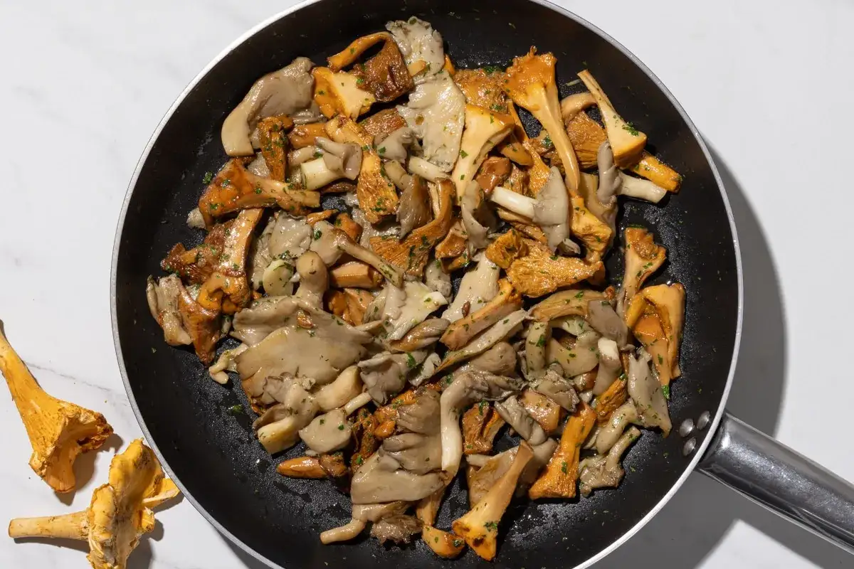 Un misto di funghi, tra cui finferli e pleurotus, saltati in padella con erbe aromatiche.