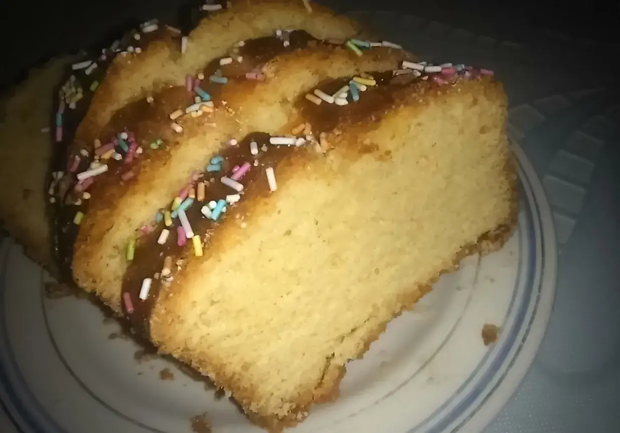 Pyszna babka wegańska z kolorową posypką, pokrojona na plastry, prezentuje się apetycznie na talerzu.