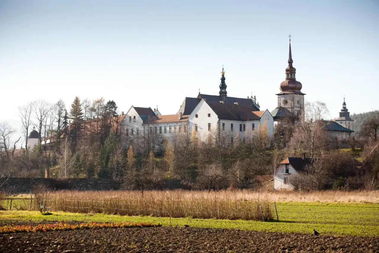 Stary Sącz atrakcje turystyczne: zesp&oacute;ł klasztorny z wieżą kościelną na tle jesiennego krajobrazu.