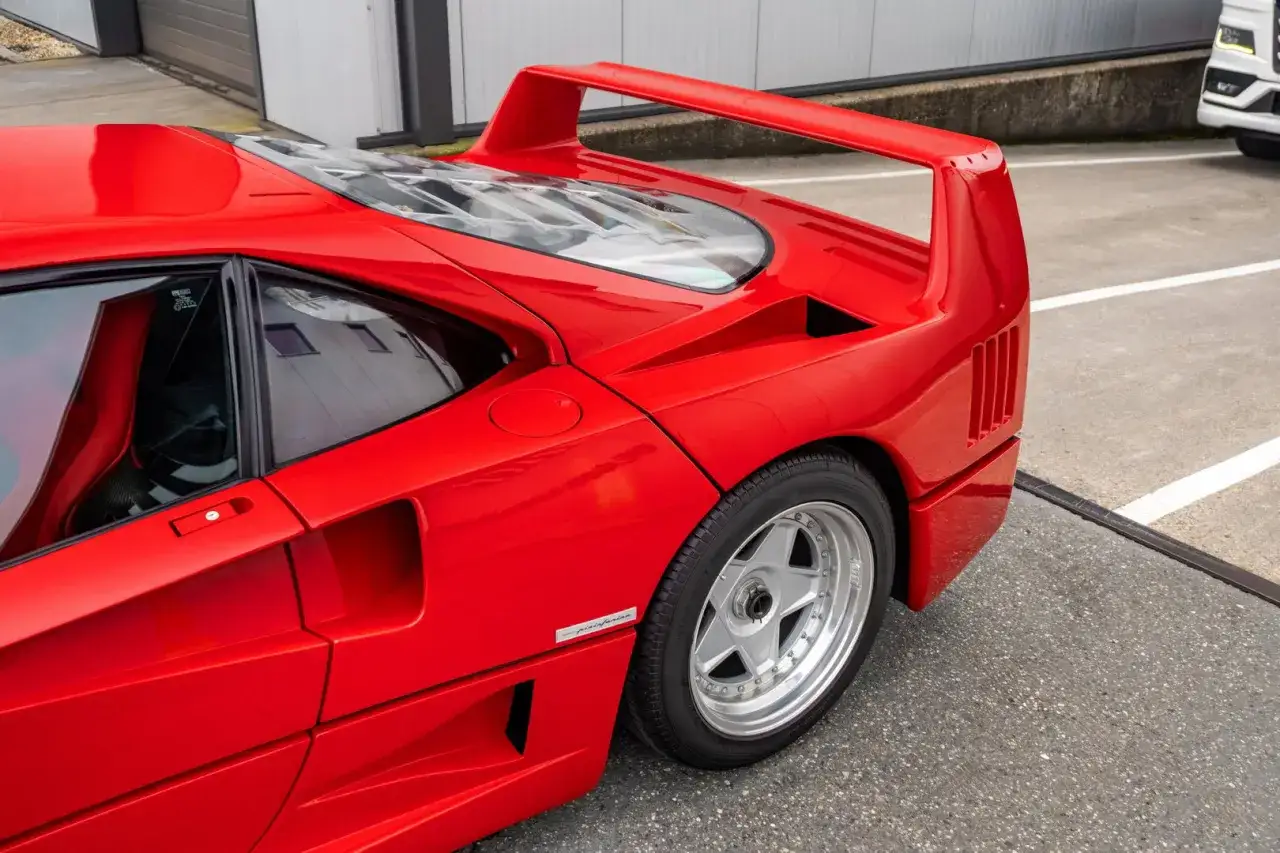 Czerwone Ferrari F40 z charakterystycznym skrzydłem i felgami. Ikona motoryzacji gotowa do jazdy.