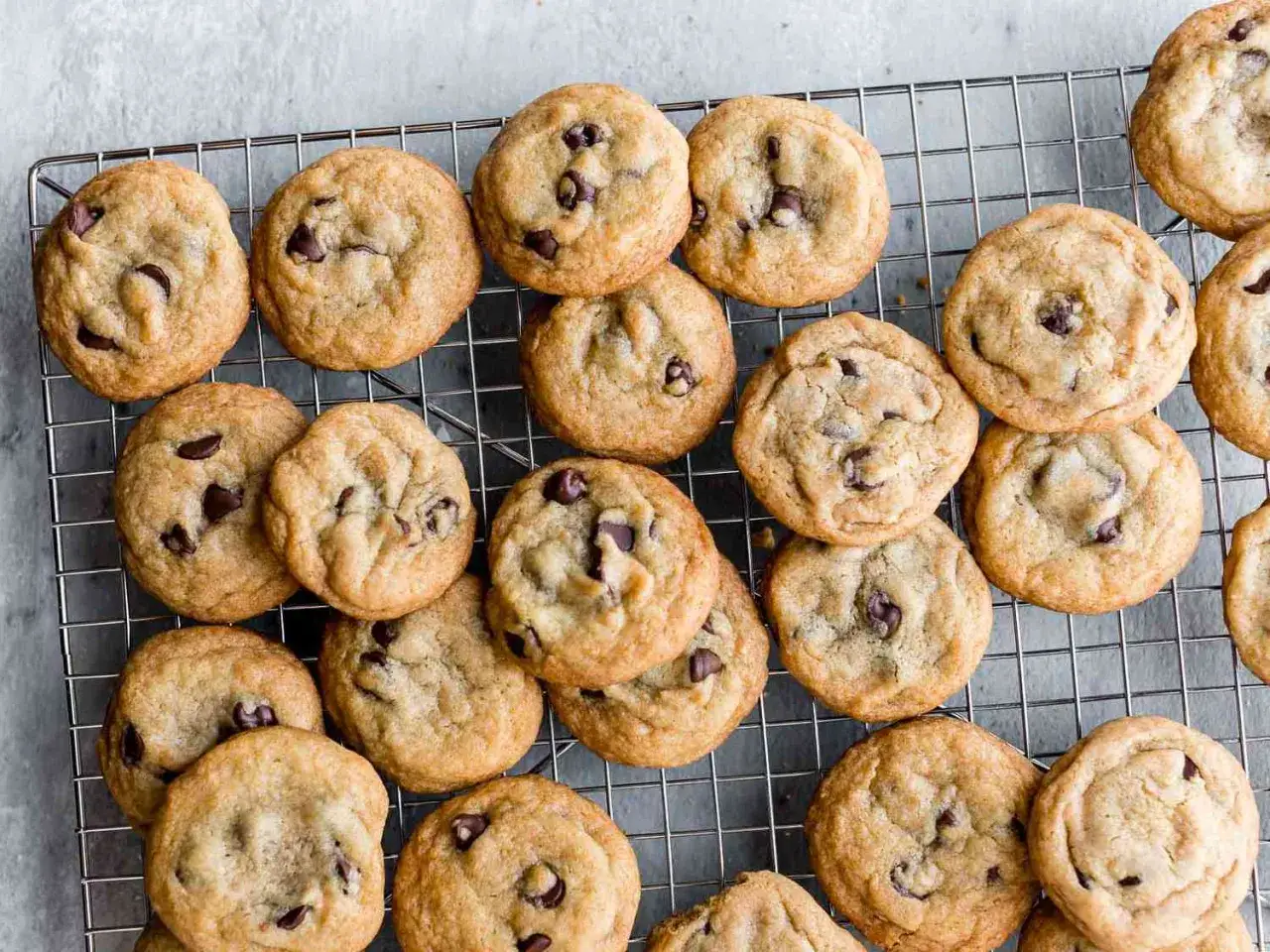 En hög med nybakade chocolate chip cookies på ett galler. Perfekt för ett enkelt chocolate chip cookies recept.