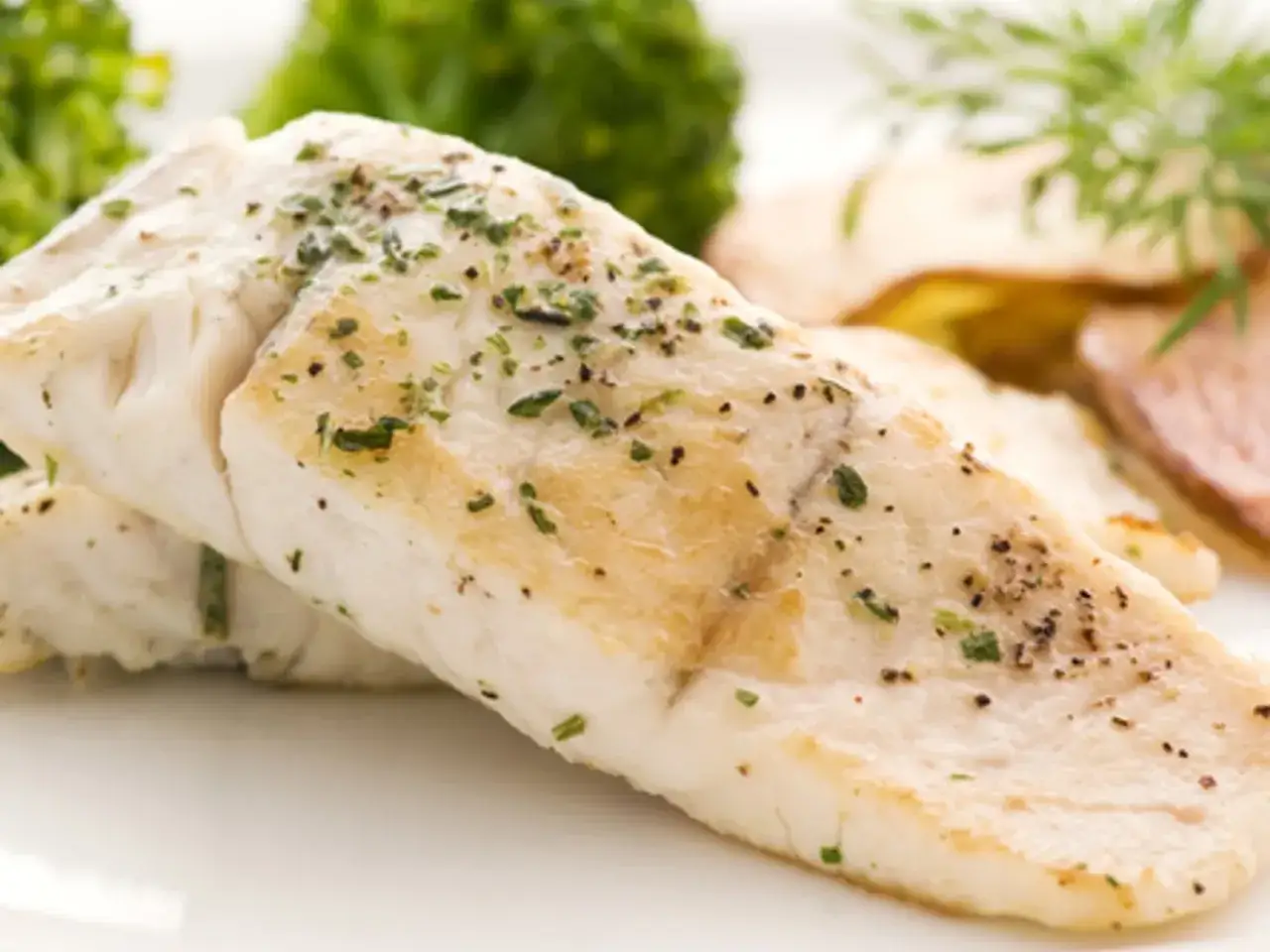 Filet de poisson aiglefin, tendre et savoureux, servi avec des légumes verts et des pommes de terre.