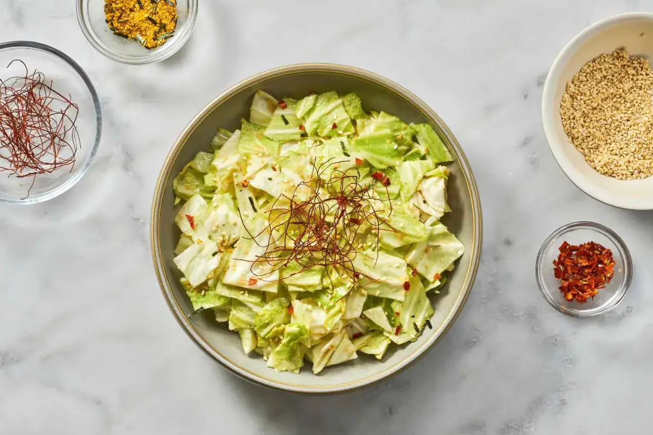 A refreshing Japanese cabbage recipe salad, tossed with a creamy dressing and garnished with chili threads and sesame seeds.