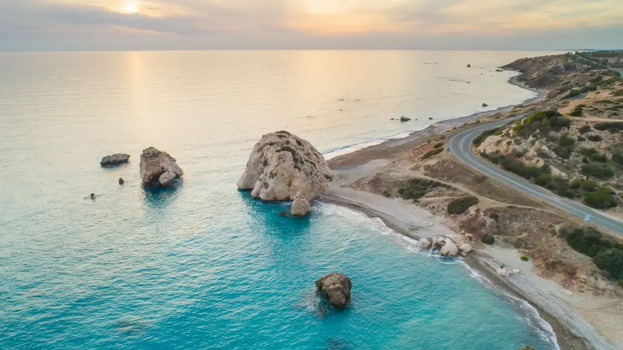Malownicze pafos plaże z turkusową wodą, skalistymi formacjami i krętą drogą wzdłuż wybrzeża.