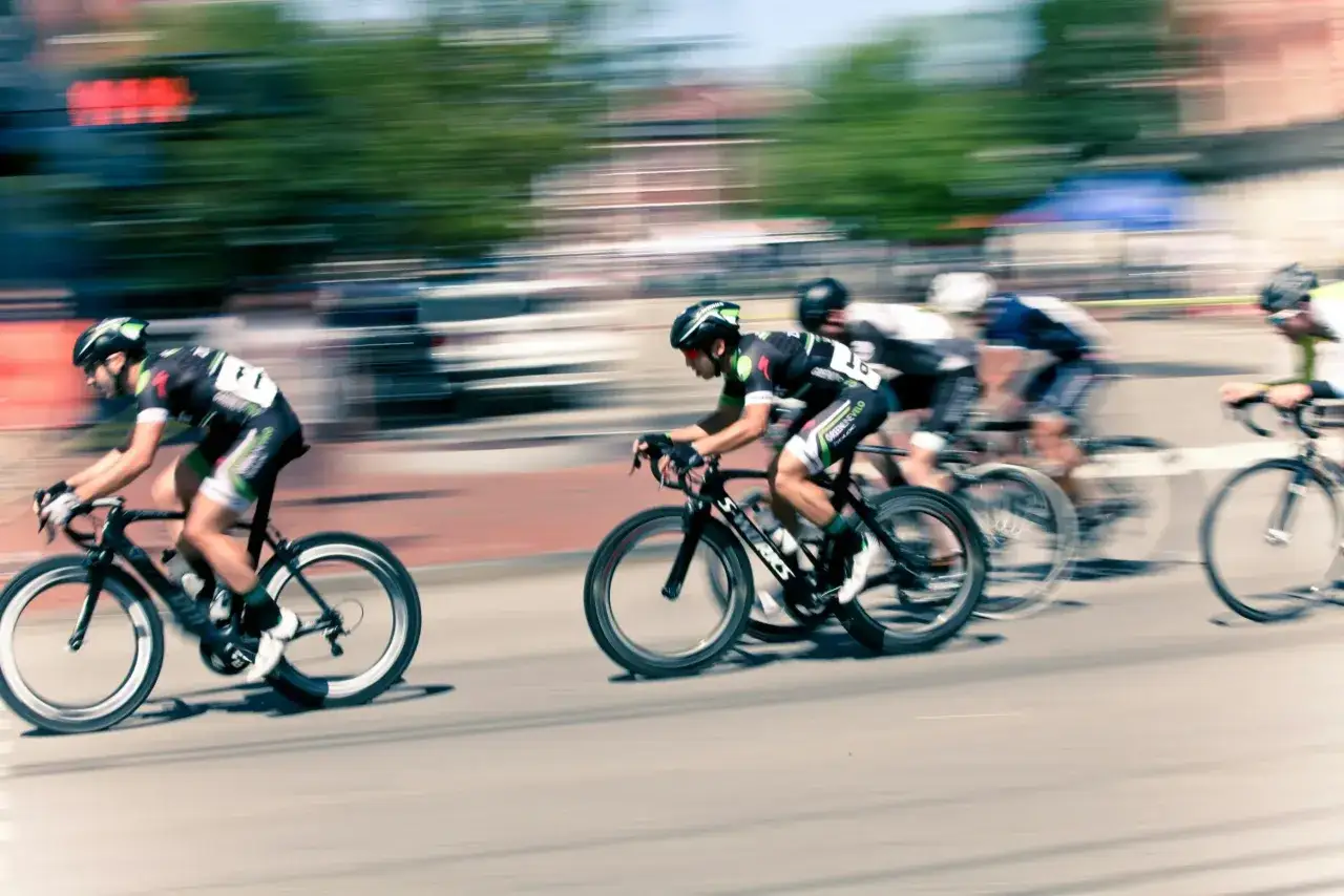 Ciclistas en plena carrera, capturados con un barrido fotográfico que resalta la velocidad y el movimiento.