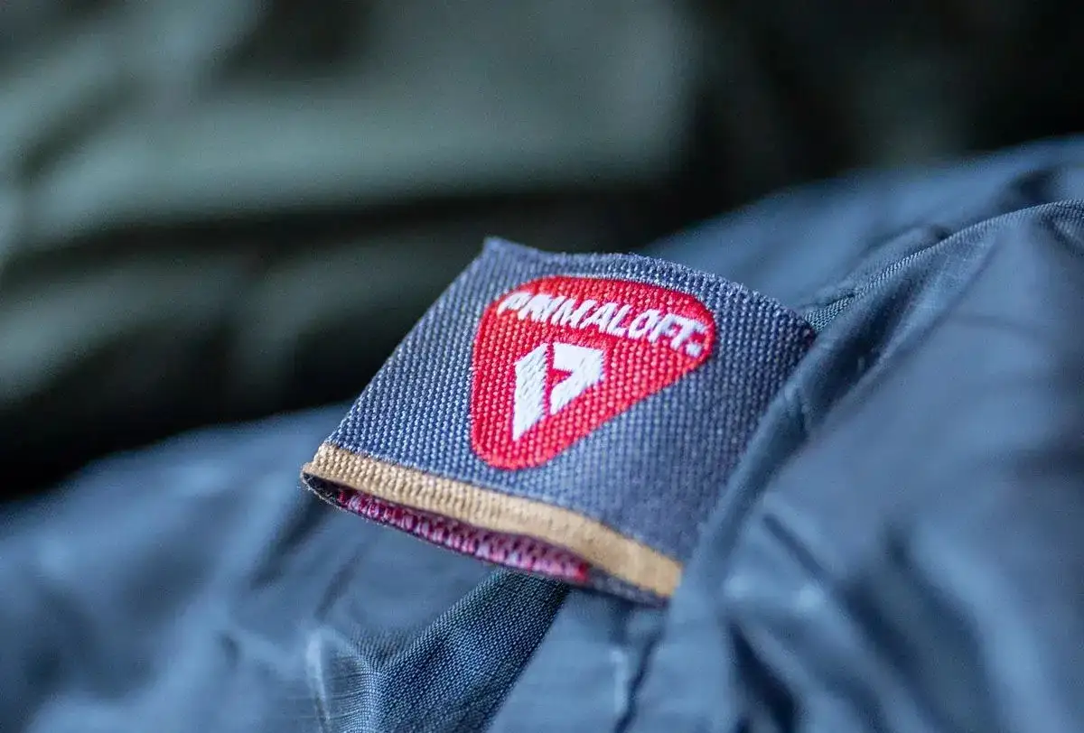 Naszywka z logo Primaloft, wskazująca na wysokiej jakości izolację. To materiał, który zapewnia ciepło i komfort.