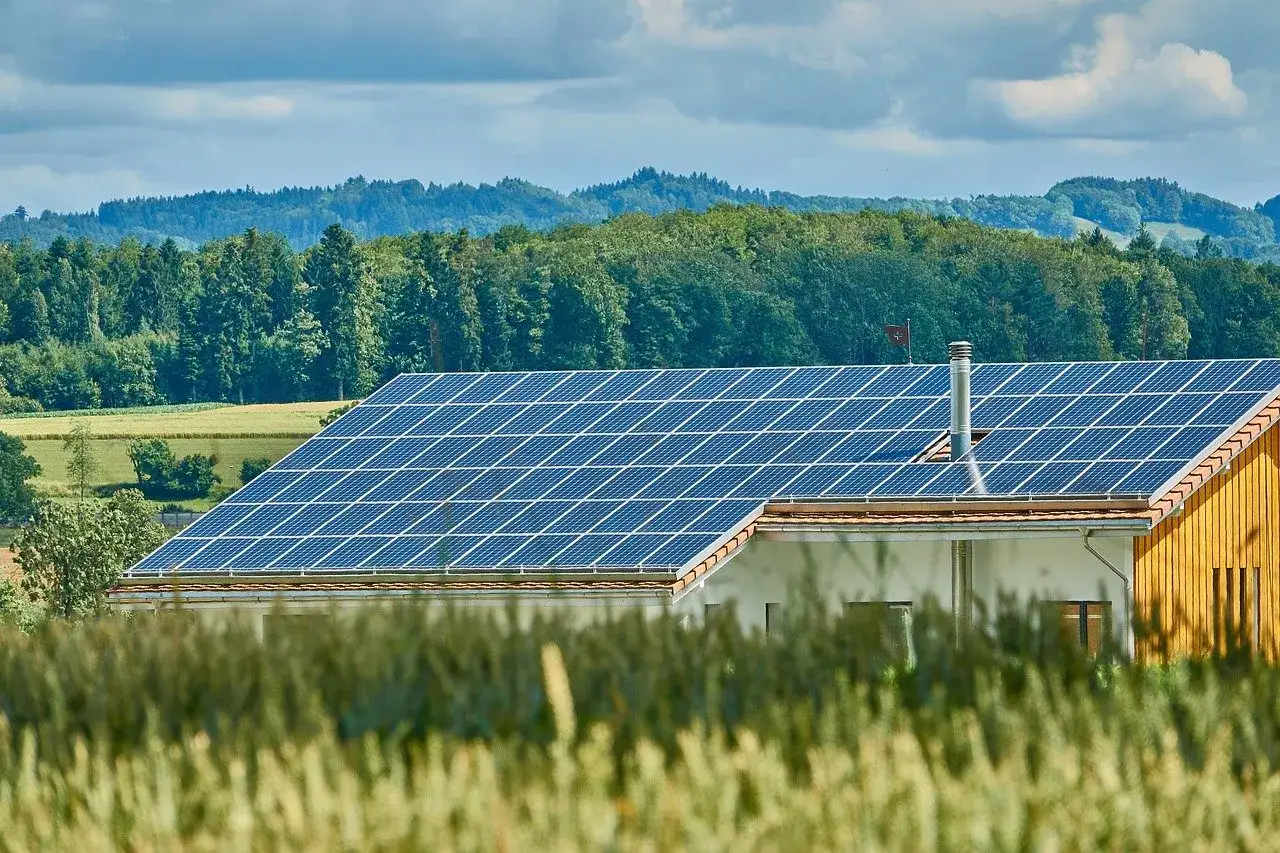Ein Haus mit Solaranlage auf dem Dach, ein Zeichen f&uuml;r Klimaschutz in Niedersachsen. Gr&uuml;ne H&uuml;gel im Hintergrund.