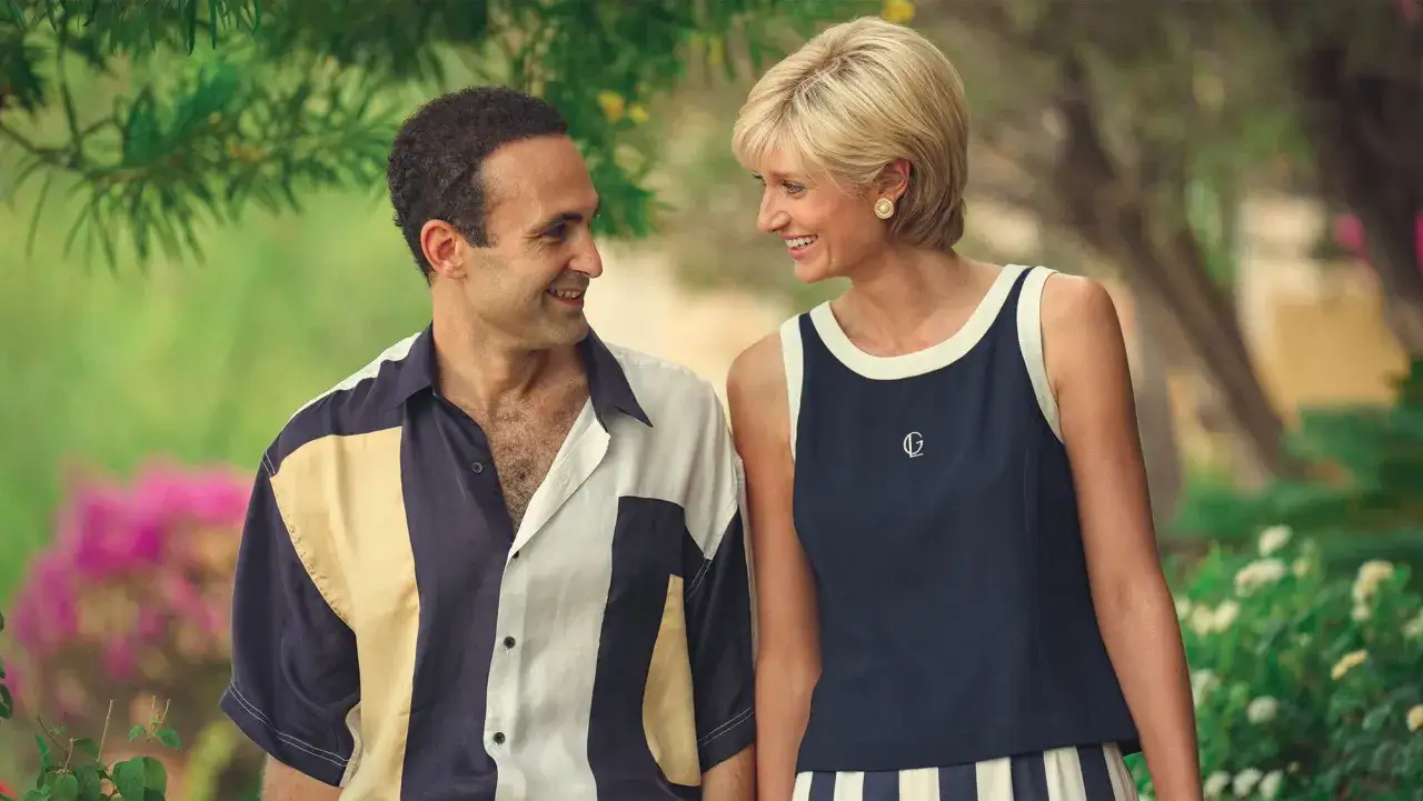 Dodi Al Fayed i księżna Diana patrzą na siebie z uśmiechem, otoczeni zielenią i kwiatami.