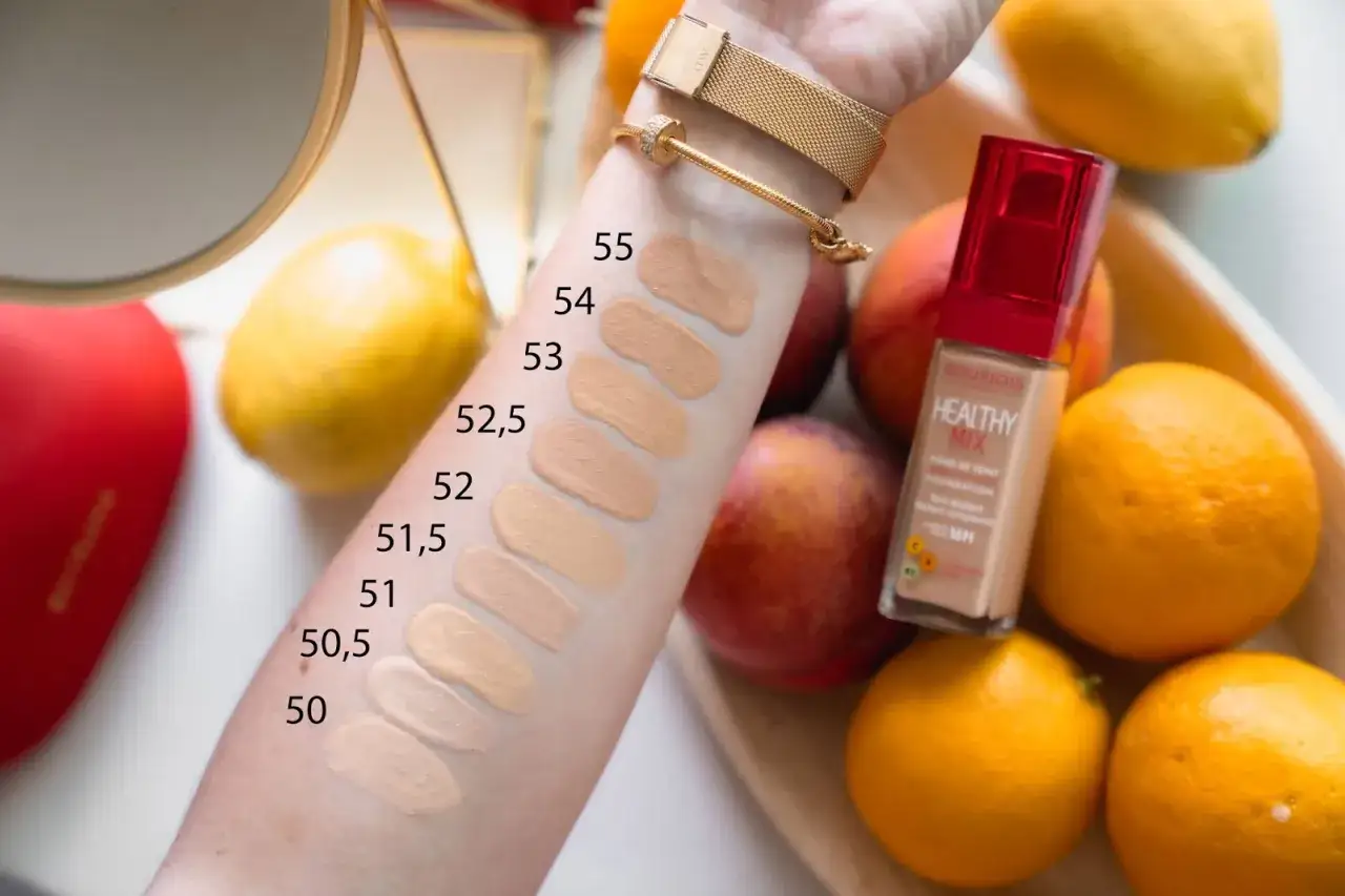 Testy odcieni podkładu Bourjois Healthy Mix na skórze. W tle owoce, które nawiązują do składu.