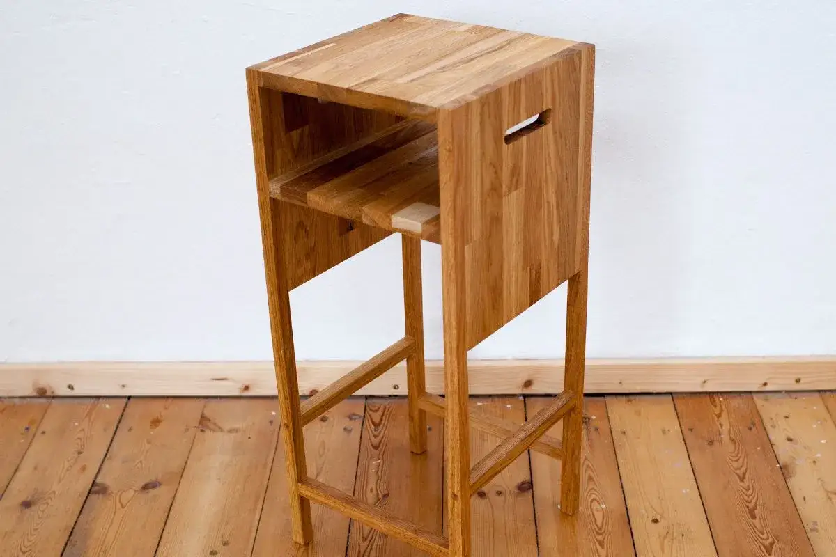 Ein schlichter Barhocker aus Holz, der zum barhocker selber bauen inspiriert. Mit integriertem Fach und Griff.
