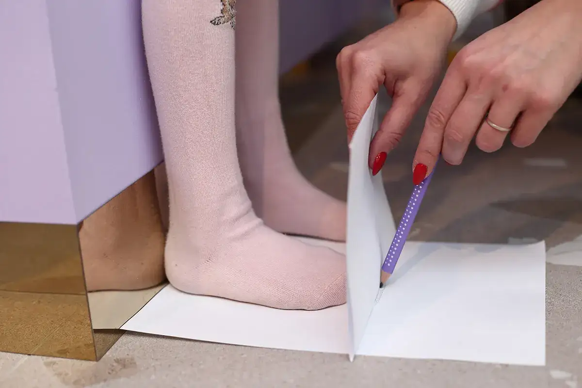 Dziecko mierzy stopę, by dobrać odpowiedni rozmiar buta. 11.5 cm jaki to rozmiar buta?