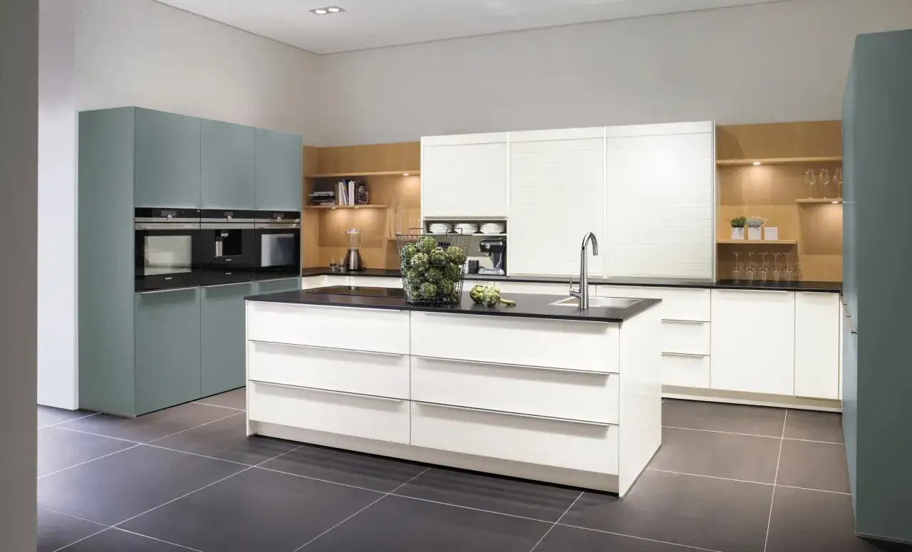 Cocina moderna con gabinetes blancos y grises, electrodom&eacute;sticos integrados y un **fregadero en isla** central.