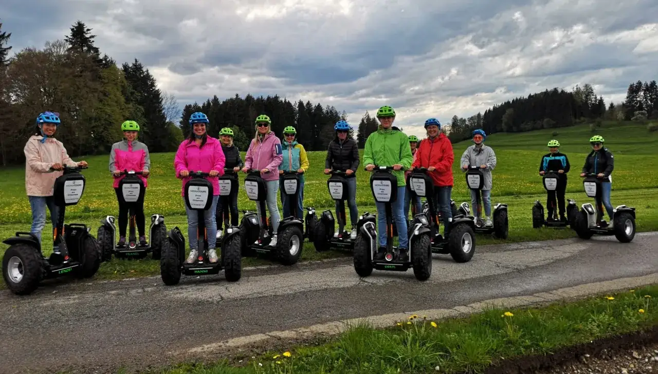 Eine Gruppe von Menschen steht auf Segways, die eine neue Art der Fortbewegung darstellen.