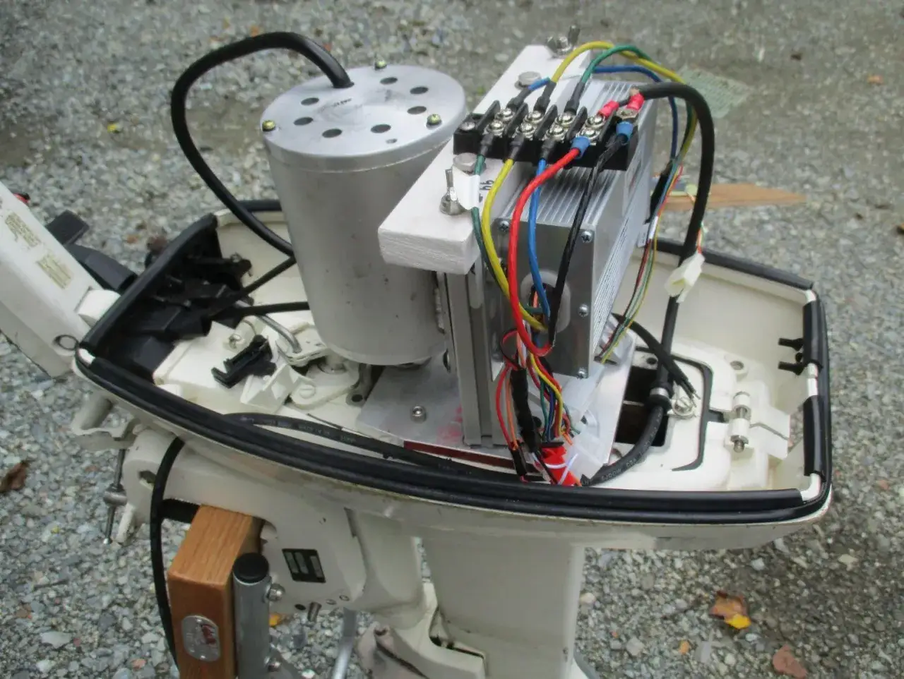 Assemblaggio fai da te di un motore elettrico per barca. Componenti visibili: motore, controller, cablaggi colorati e supporto in legno.