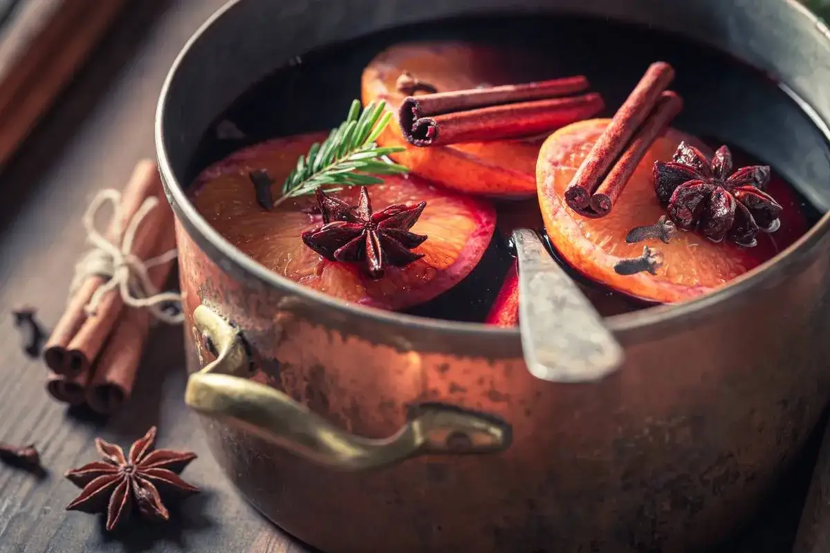Un vin chaud r&eacute;confortant mijote dans une marmite en cuivre, garni d'oranges, de cannelle et d'anis &eacute;toil&eacute;. Parfait pour savoir quel vin pour le vin chaud.