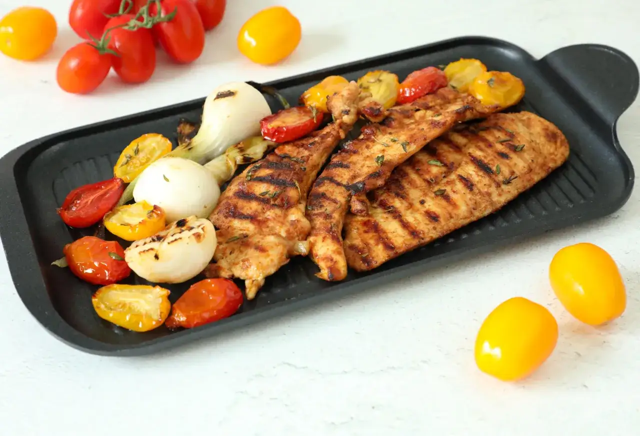 Petto di pollo alla piastra con pomodorini e cipolle, una deliziosa salsa per accompagnare.