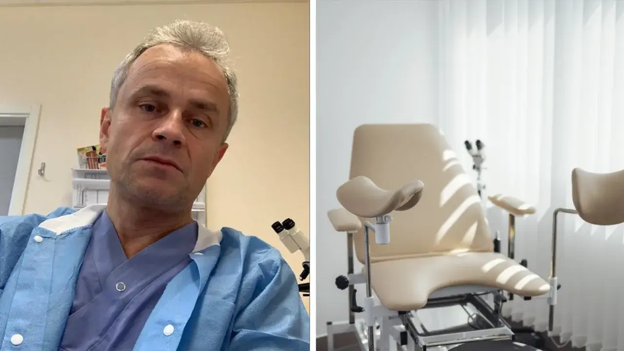 Manlig gynekolog i blå skyddsrock framför en gynekologstol.