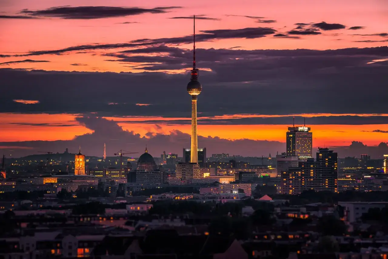 Panorama Berlino al tramonto, con la Torre della Televisione illuminata e il cielo infuocato.