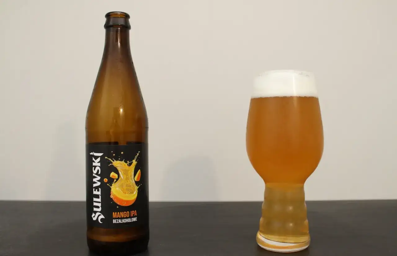Butelka i szklanka z piwem mango ale. Orzeźwiający napój na lato.
