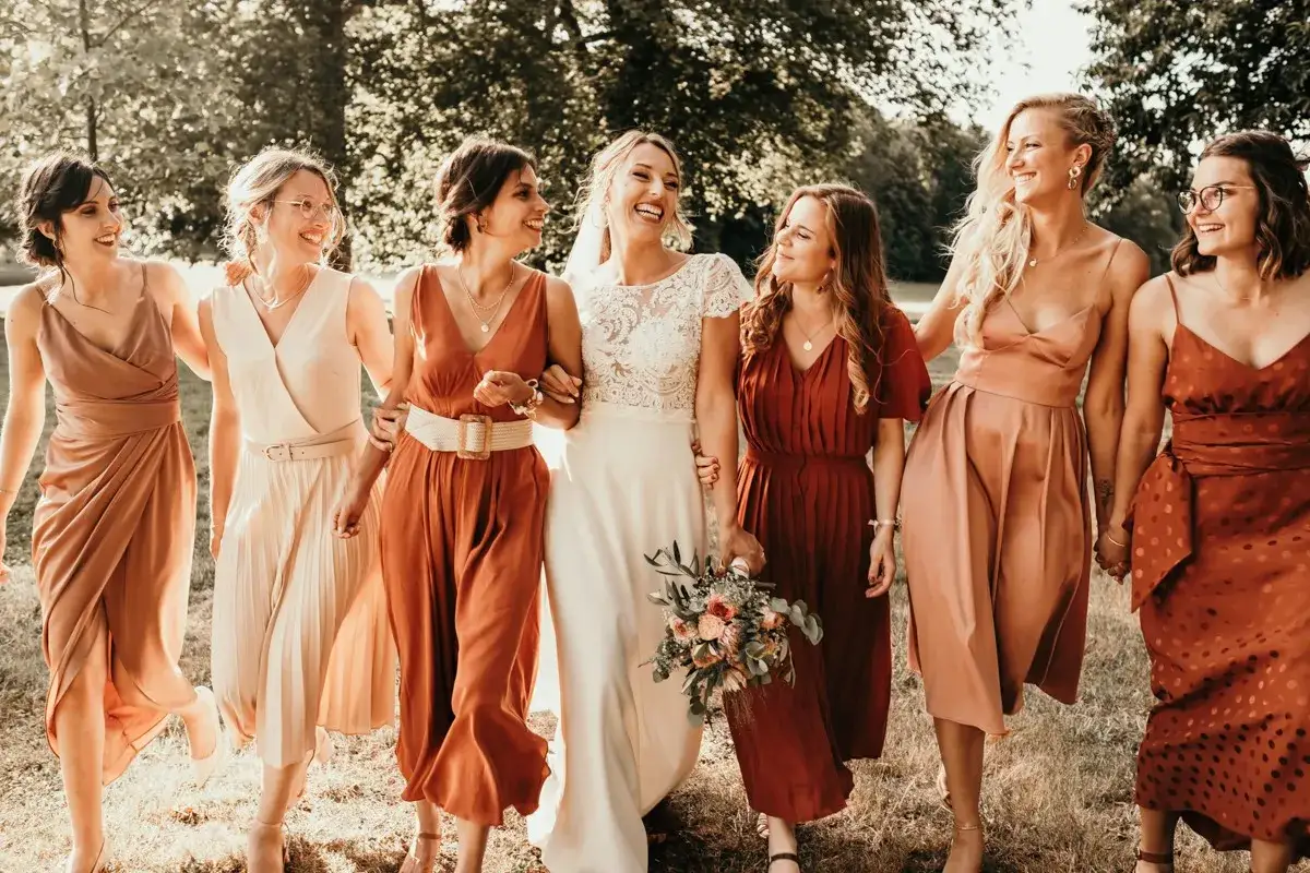 La mariée et ses demoiselles d'honneur arborent des robes aux tons chauds, créant une harmonie de couleur demoiselle d'honneur parfaite pour un mariage d'automne.