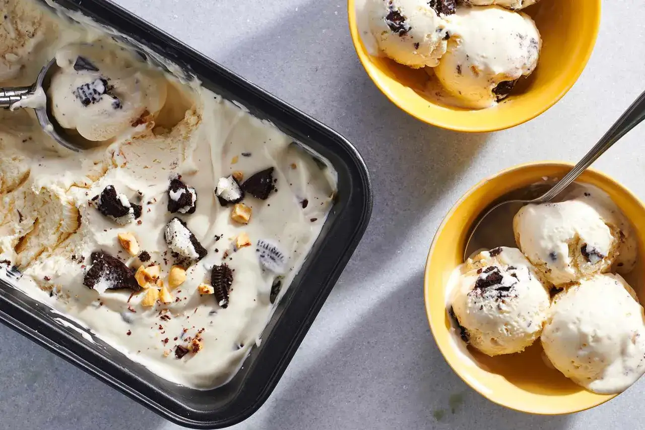 Cremiges Eis mit Keksen und N&uuml;ssen, verfeinert mit gezuckerter Kondensmilch. Serviert in einer Sch&uuml;ssel und einer Schale.