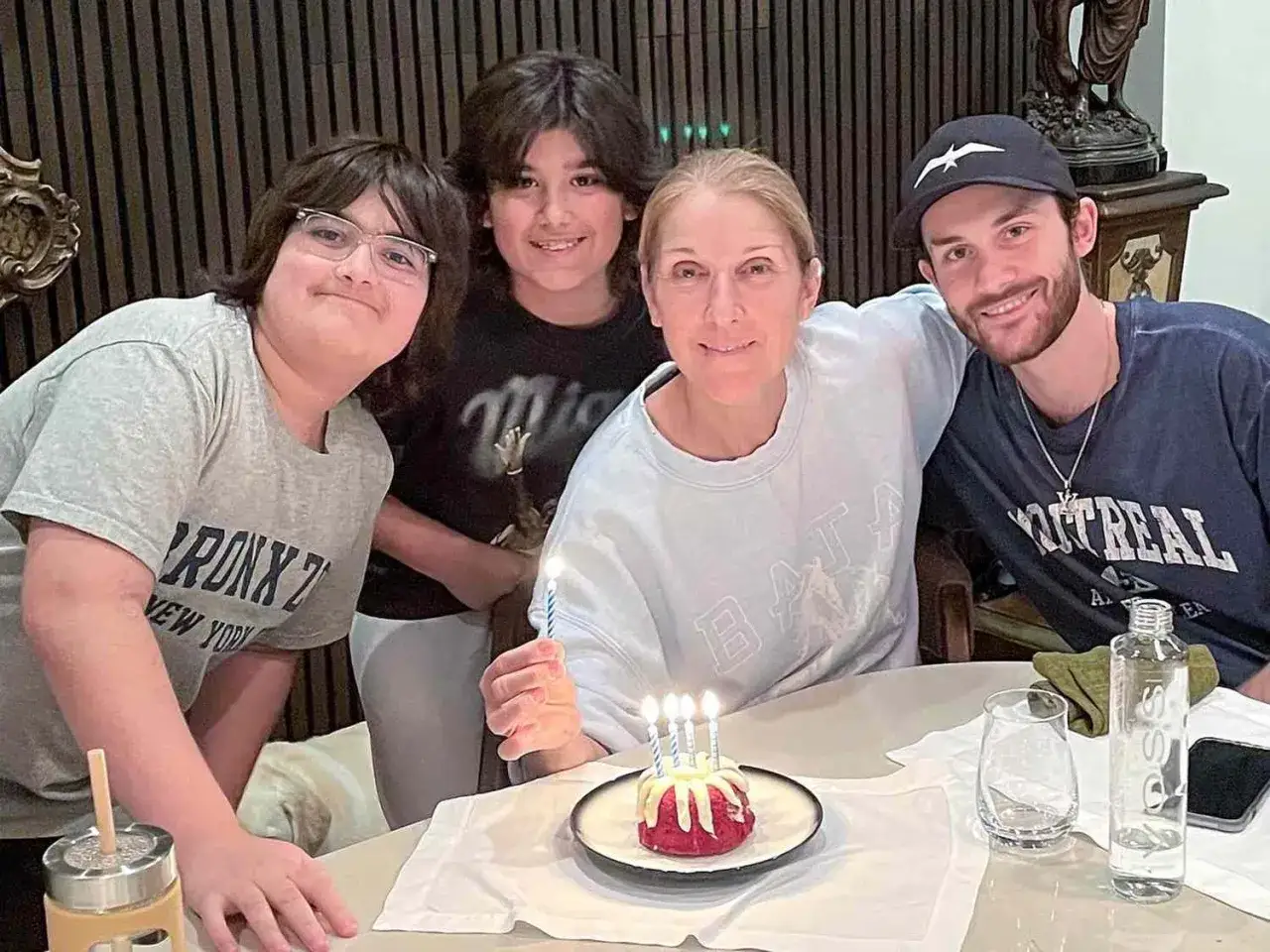 Celine Dion firar med sina barn och en tårta med ljus.
