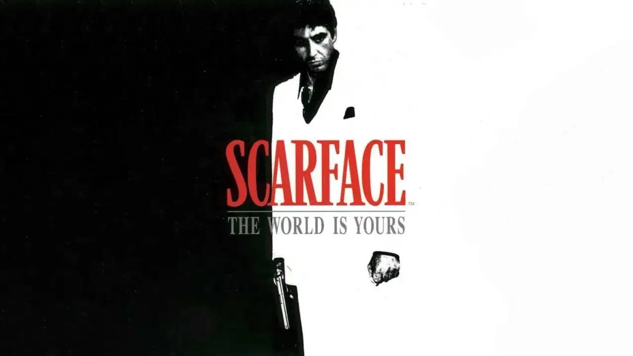 Tony Montana w białym garniturze, z pistoletem u boku, na tle napisu SCARFACE THE WORLD IS YOURS.