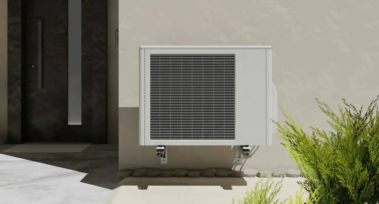 Unité extérieure de clim 2.5 kW, idéale pour rafraîchir environ 25 m². Installée près d'une porte d'entrée moderne.