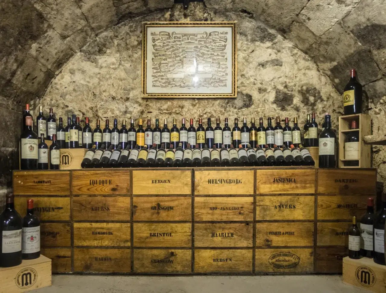 Bottiglie di vino e casse di legno in una cantina, un esempio di come conservare il vino in cantina.