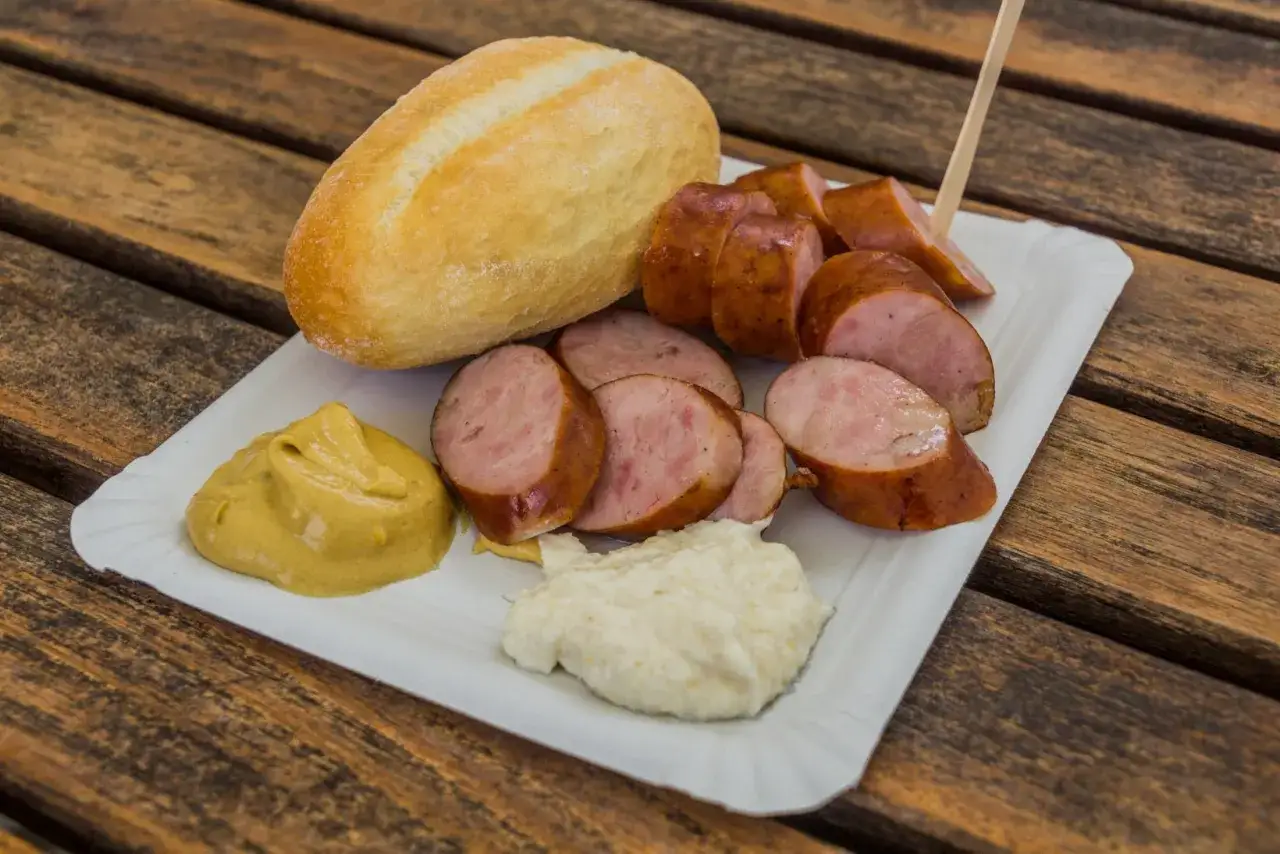 Kiełbasa, bułka i musztarda na talerzyku &ndash; klasyka kuchni słoweńskiej.