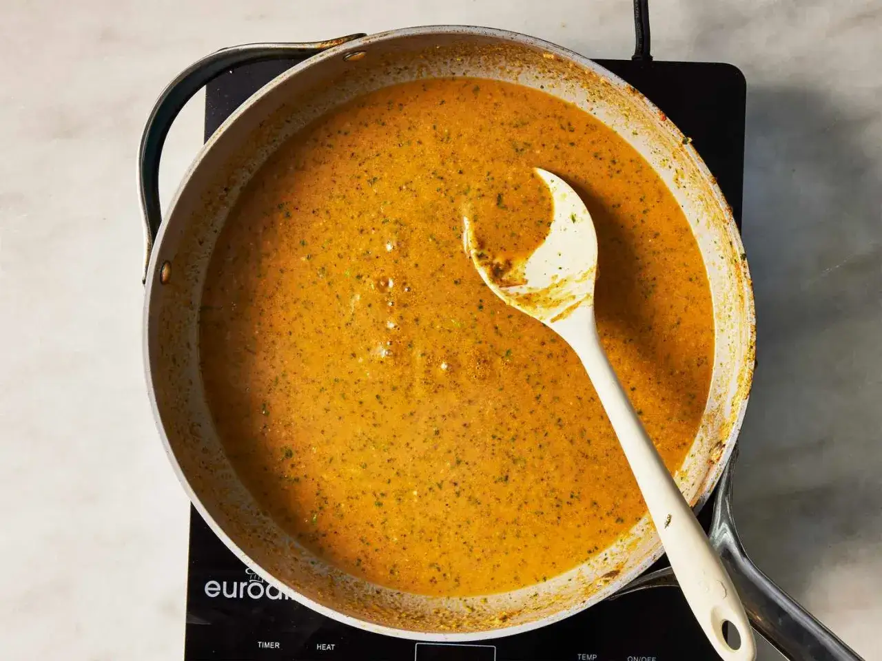 Une sauce curry cr&eacute;meuse mijote dans une po&ecirc;le, pr&ecirc;te &agrave; &ecirc;tre servie.