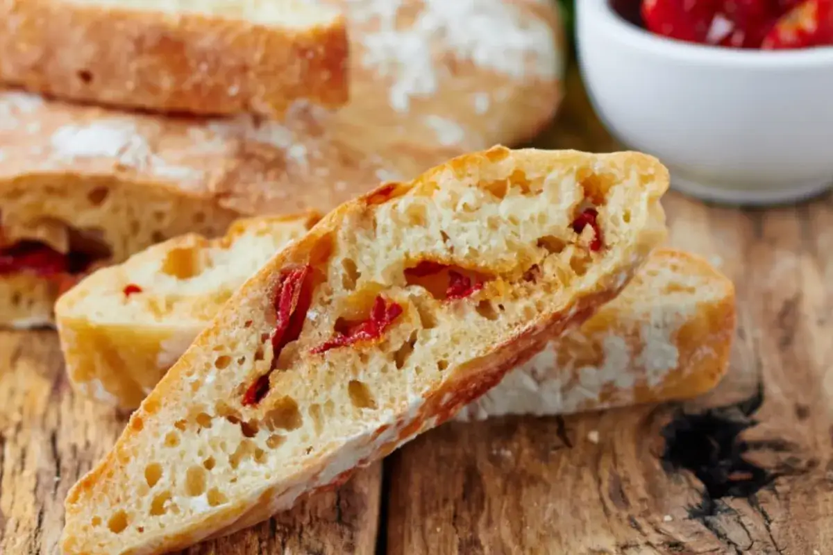 Frisches Ciabatta mit Tomaten, auf einem rustikalen Holzbrett angerichtet. Perfekt für eine leichte Mahlzeit.