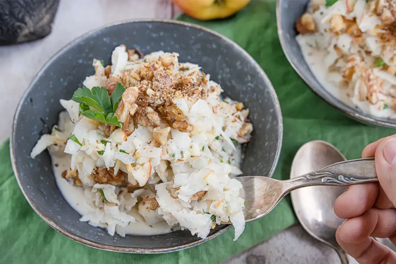 Schwarzer Rettich Zubereitung: Ein cremiger Salat mit Waln&uuml;ssen und Petersilie, serviert in einer Sch&uuml;ssel.